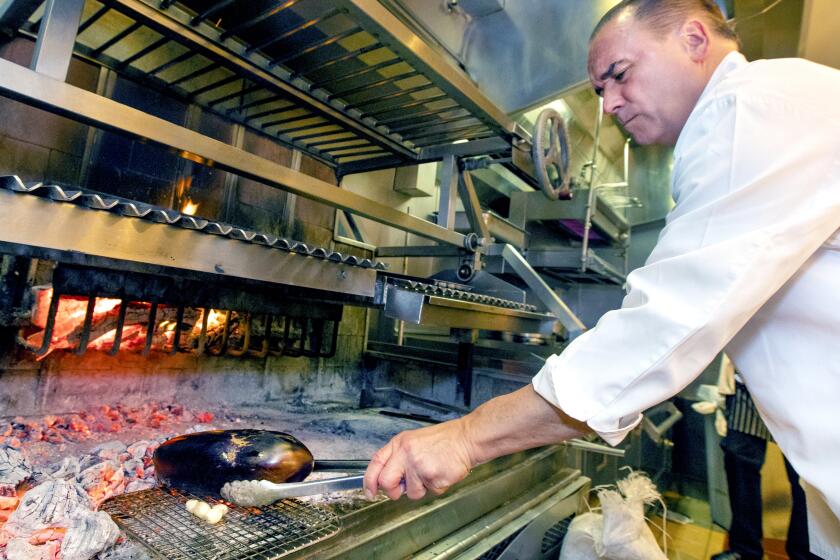 SANTA MONICA, CA-MAY 21, 2019: Chef Jean-Georges Vongerichten grills an eggplant, working inside the kitchen of his restaurant, Jean-Georges Beverly Hills at the Waldorf Astoria. (Mel Melcon/Los Angeles Times)