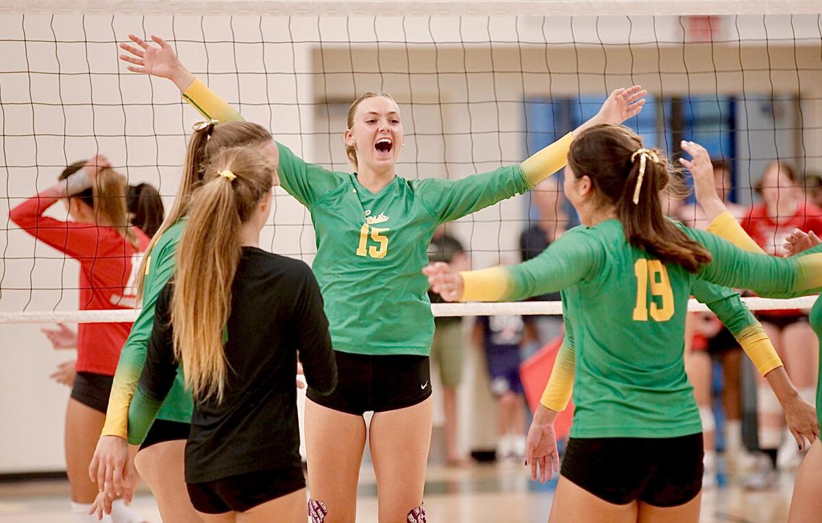 Mira Costa's Rachel Moglia, center, celebrates a three-set win over Mater Dei on Tuesday night in Manhattan Beach.