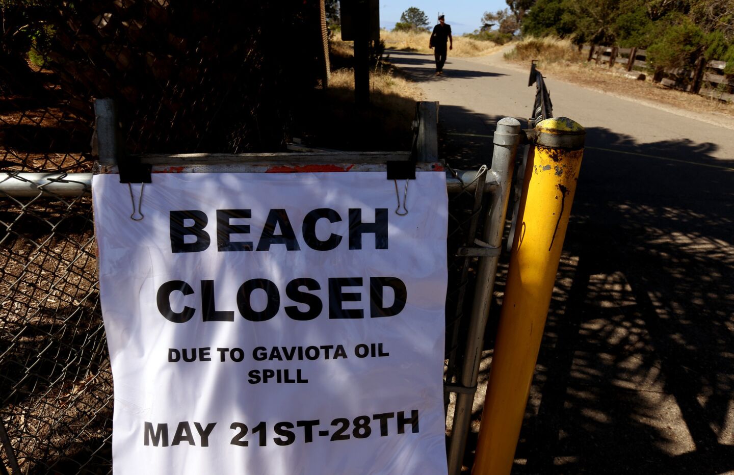 A "Beach Closed" sign is posted at Coal Oil Point in Isla Vista. Many state beaches have been closed in the area, but some people still made their way to the shore.
