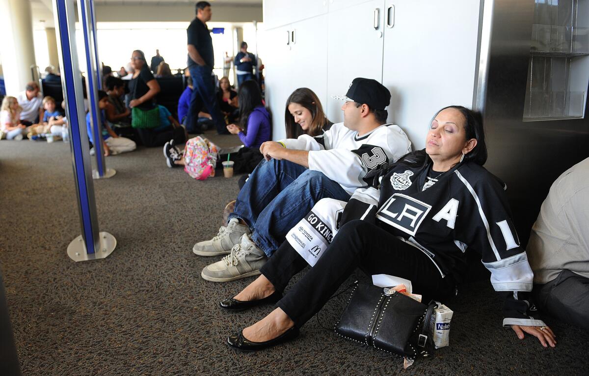 Travelers wait for their flight at Terminal 1 after a computer glitch led to the grounding of all departures Wednesday afternoon at Los Angeles International Airport.
