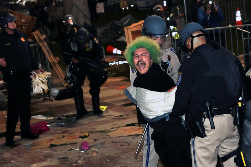 LOS ANGELES, CALIFORNIA - May 2: Police officers arrest a pro-Palestinian protester after an oder to disperse was given at UCLA early Thursday morning. (Wally Skalij/Los Angeles Times)