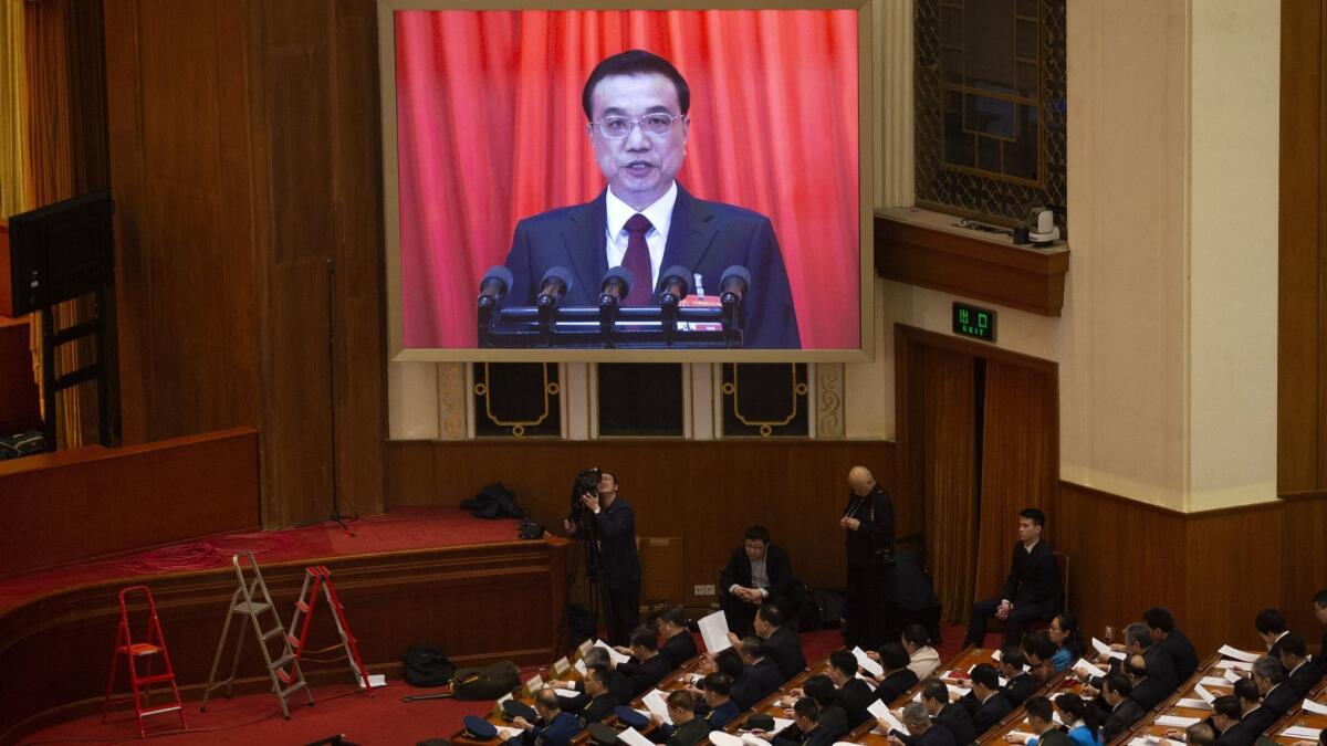 Chinese Premier Li Keqiang is seen on a big screen as he delivers the work report Tuesday at the opening session of the annual National People's Congress in Beijing's Great Hall of the People.