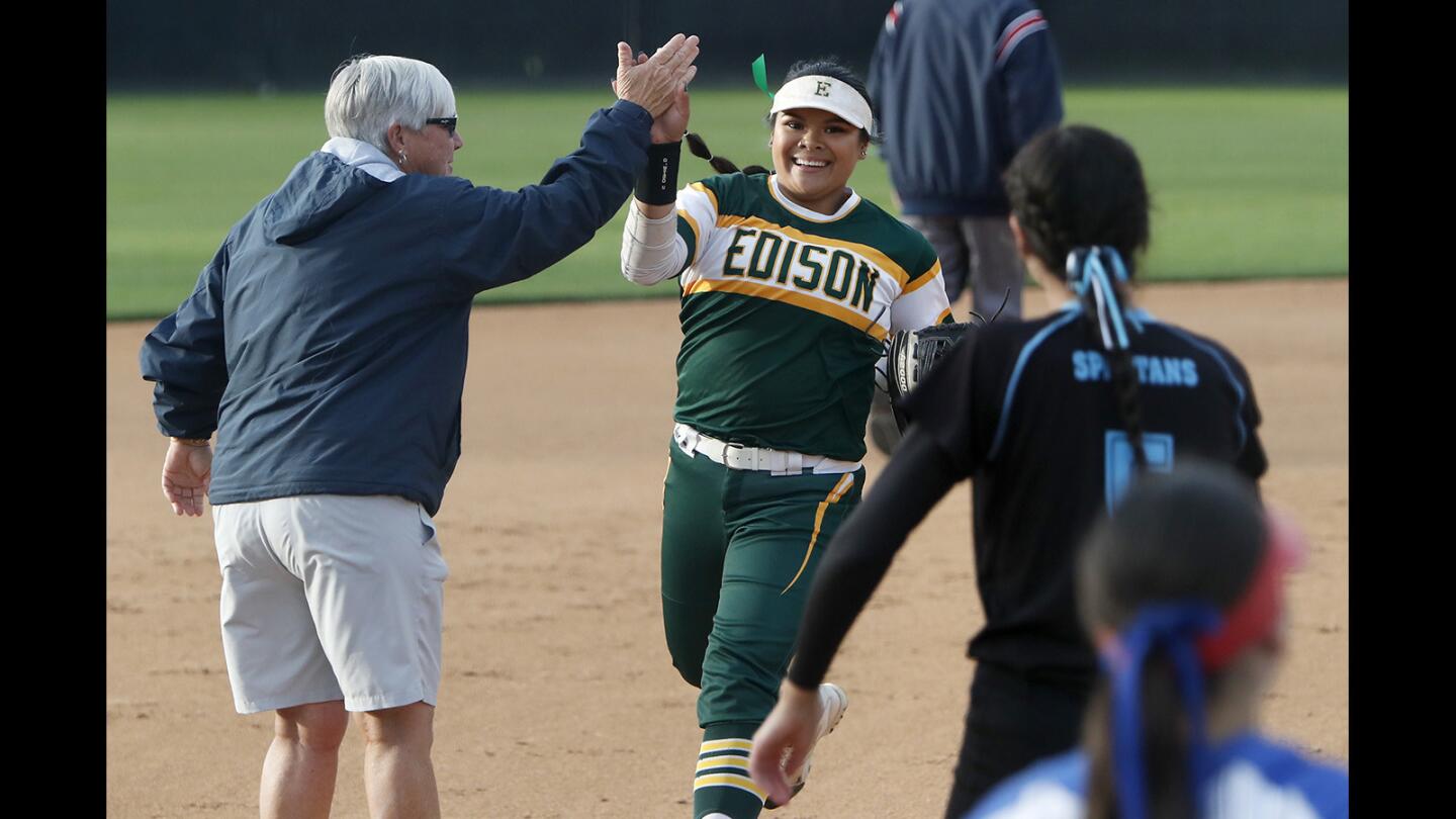 Edison's Jaelyn Operana, center, gets a high-five from Marina coach Shelly Luth after she helped turn a triple play in the top of the first inning of the Orange County Softball Coaches All-Star Classic on Tuesday at Deanna Manning Stadium in Irvine.