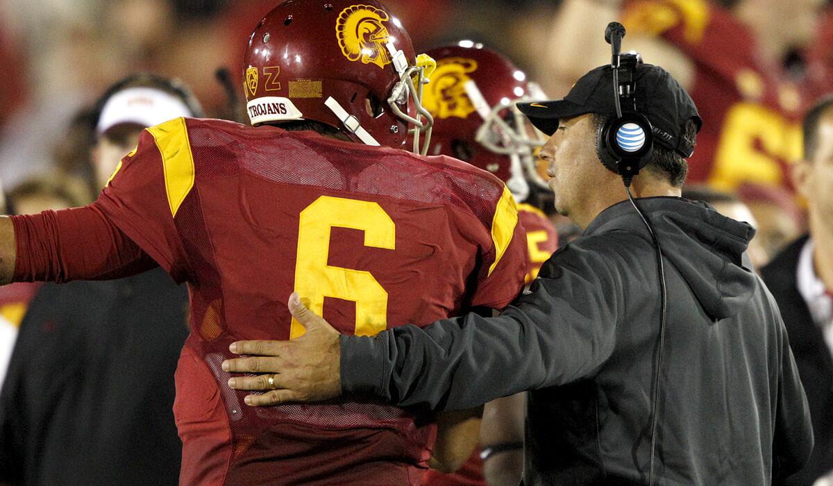 Trojans quarterback Cody Kessler (6) walks along the sideline with Coach Steve Sarkisian after USC took a 35-10 lead over Oregon State in the fourth quarter.