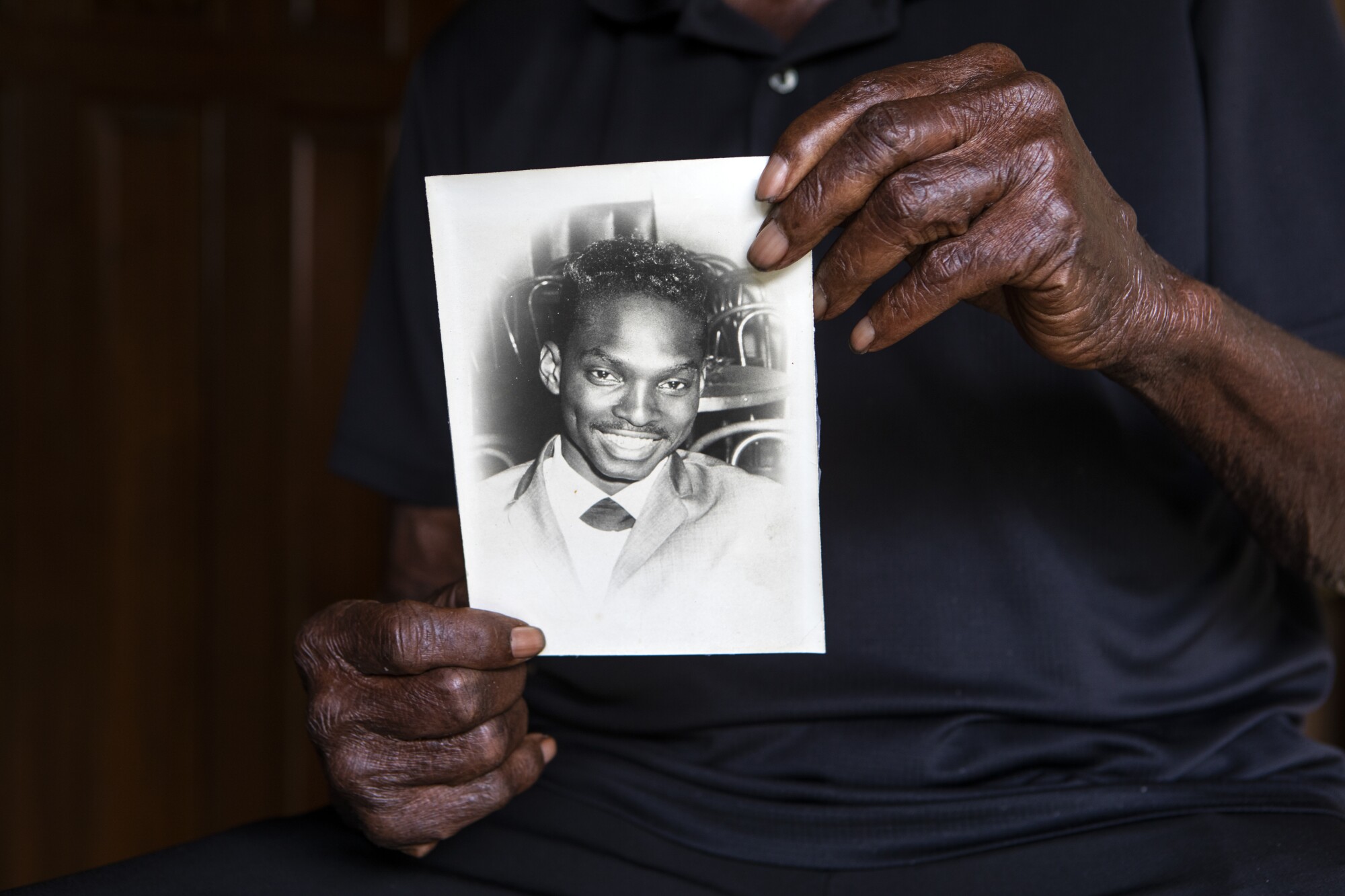 Robert Meeks Jr., 82, holds a portrait of himself as a young man. 