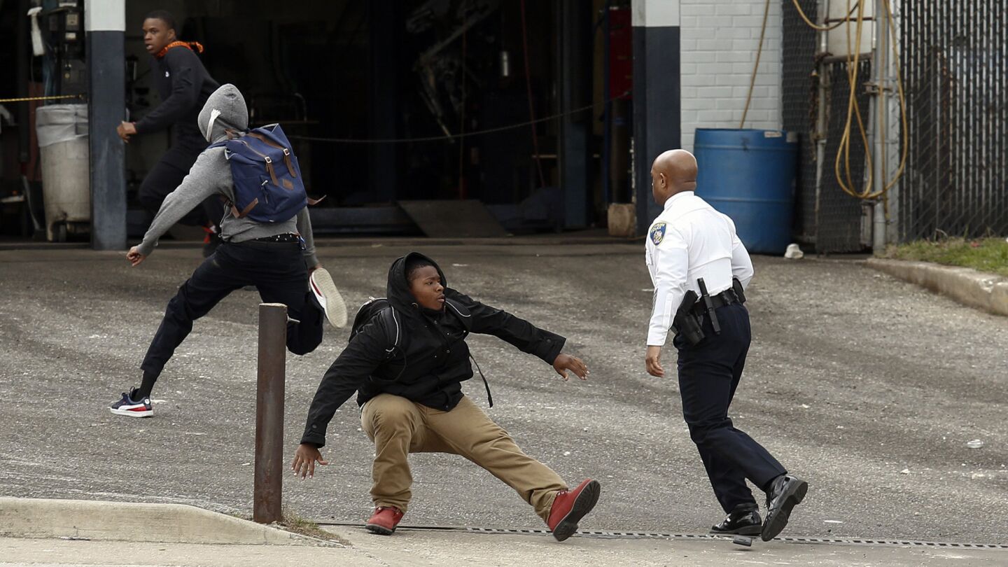Baltimore Police Commissioner Anthony Batts chases away protesters in a parking lot near Mowdamin Mall.