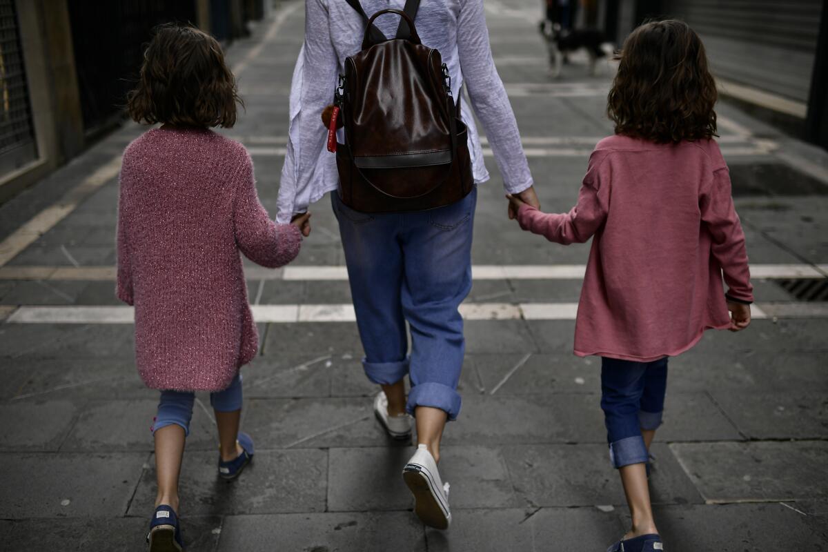 A family takes a walk in Pamplona on Sunday as children under 14 were allowed in public.