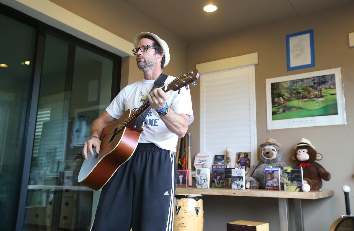 James Lowe, also known as "Coach Ballgame," opens his popular online, live streaming physical education class with a song about one of his baseball heroes from his home studio.