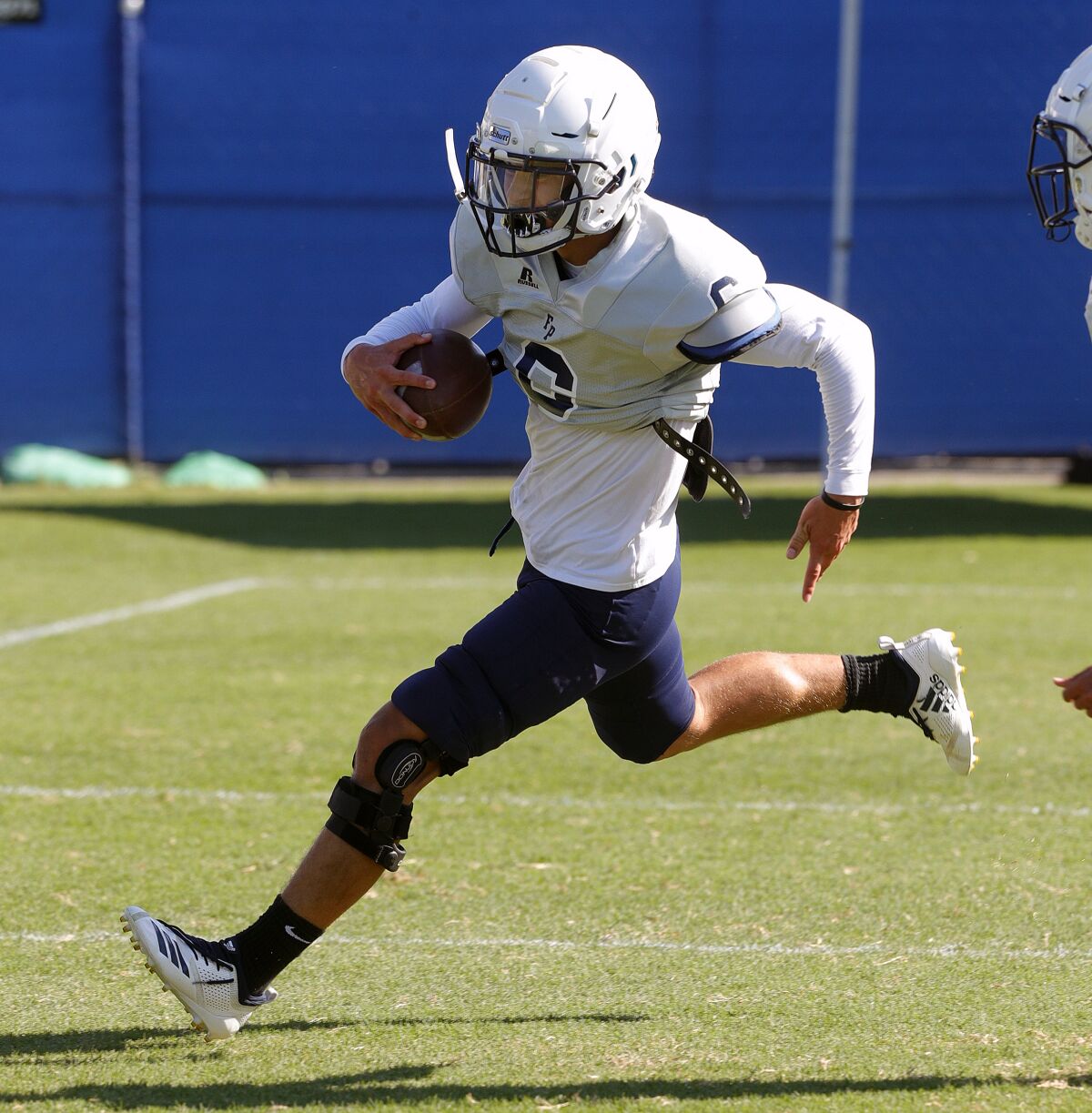 Flintridge Prep's Tommy Porter carries the ball on a run while practicing play at pre-season football practice at Flintridge Prep on Monday, August 19, 2019.