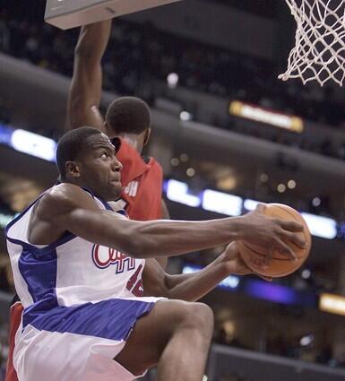 Clipper Elton Brand drives under the basket for two points, passing by Toronto Raptor Chris Bosh.