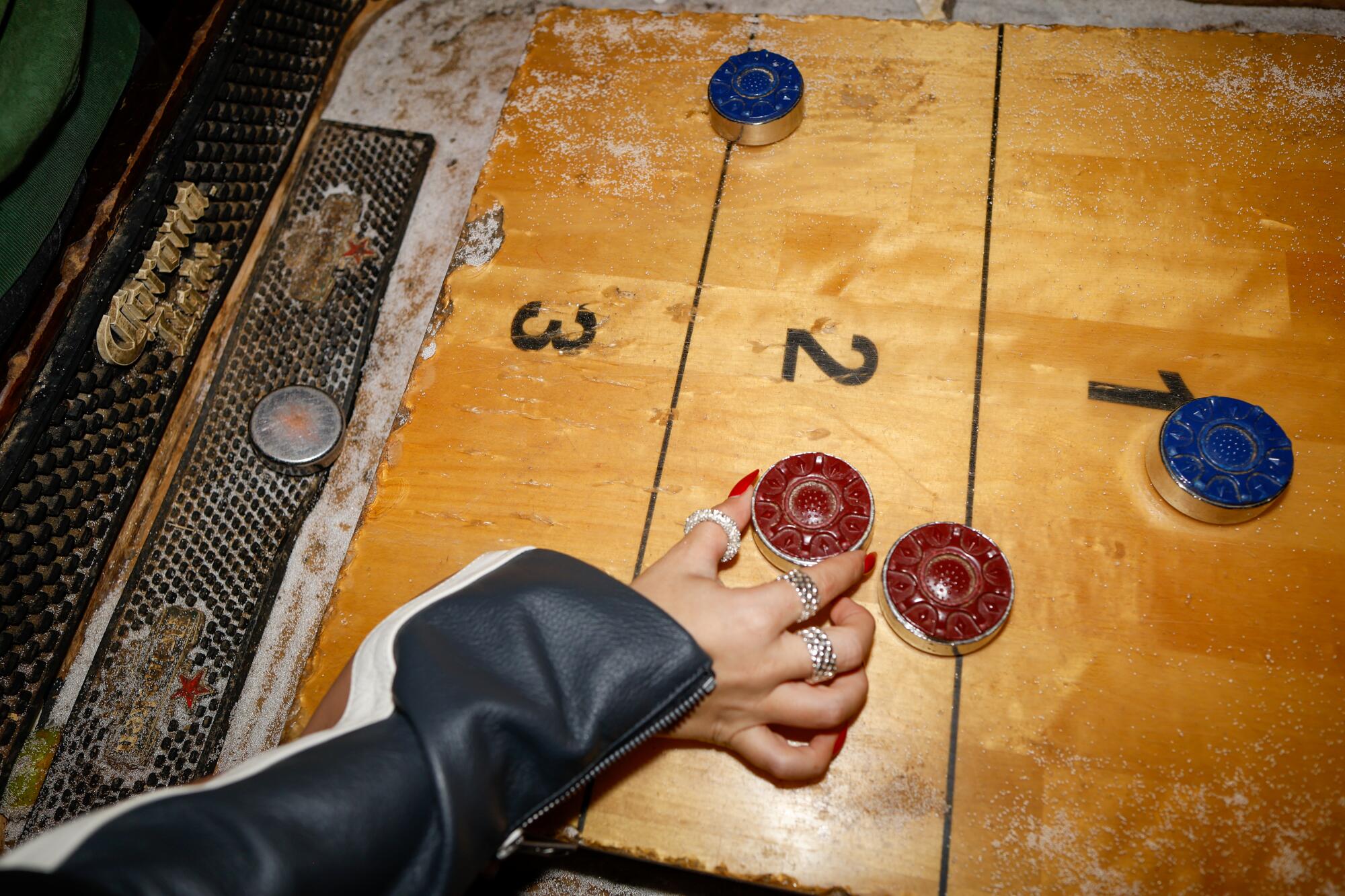 A well-used shuffleboard sees some action on a bustling Saturday night at Barney's Beanery.