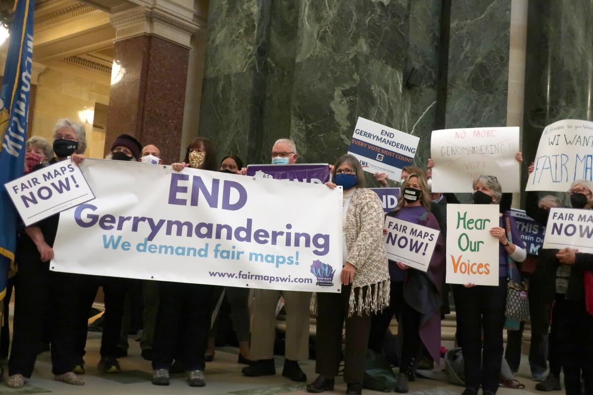 People hold a banner that reads, "End gerrymandering."