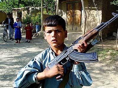 A young member of the Northern Alliance clasps an assault rifle near the Afghan village of Denou.