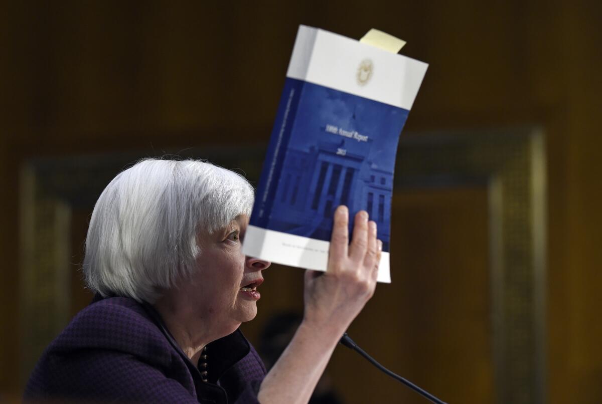 Federal Reserve Board Chair Janet Yellen holds up a copy of the 100th Annual Report from the Federal Reserve as she testifies on Capitol Hill Tuesday.