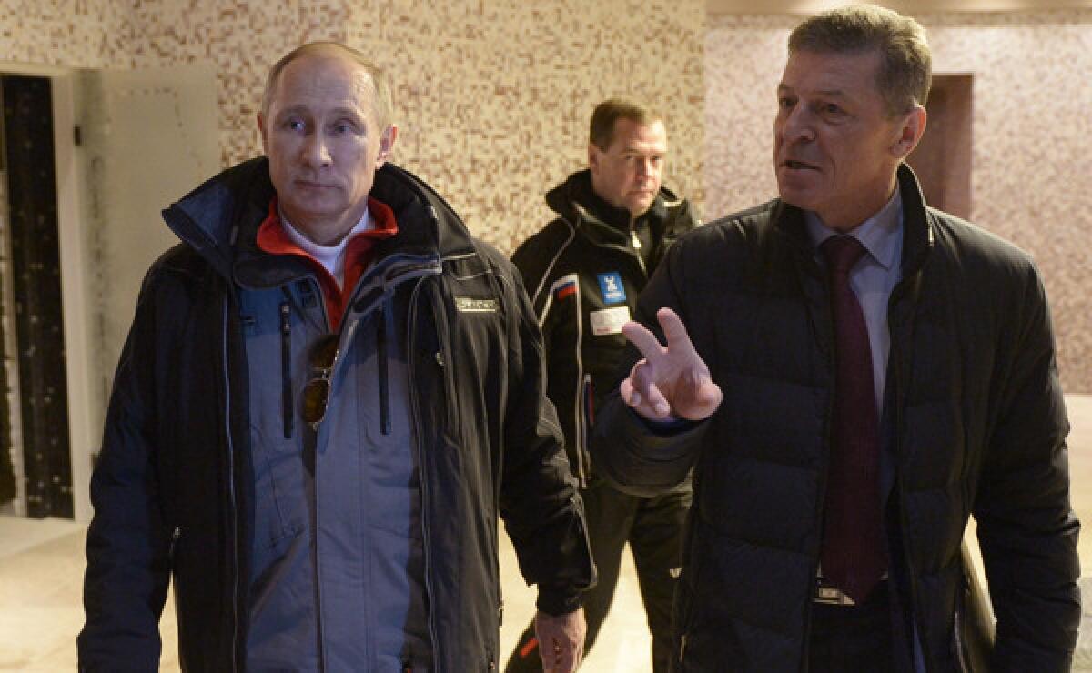 Russia President Vladimir Putin, left, listens to Russian deputy prime minister Dmitry Kozak, right, speak about preparations for the Winter Olympic Games during a visit to Sochi, Russia, on Jan. 3. Tens of thousands of Russian police and military personnel have been deployed to the Olympic host city to provide security against terrorist attacks.