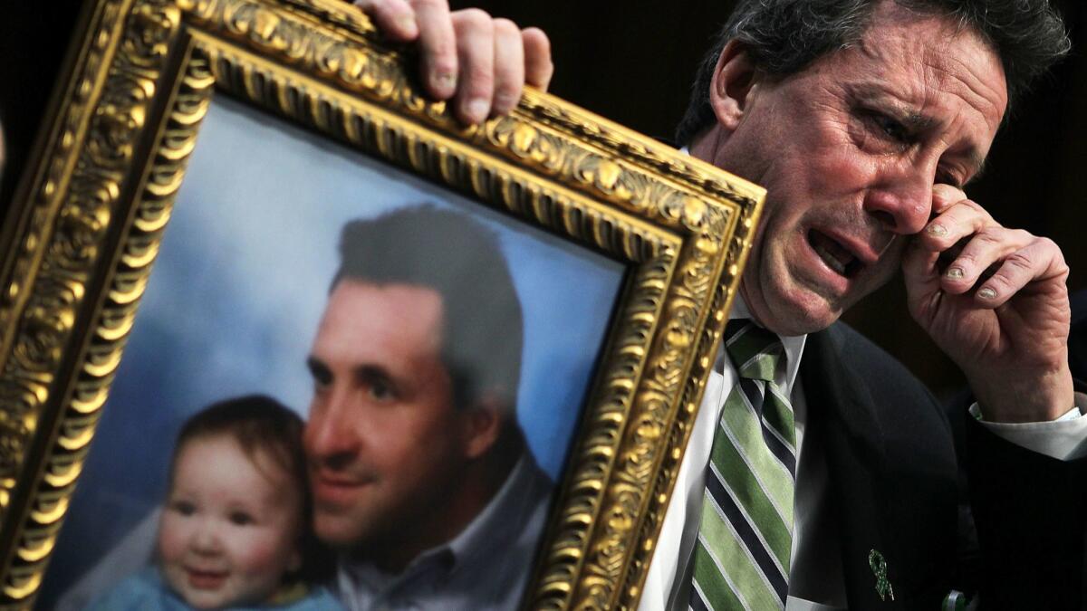 Neil Heslin, father of Sandy Hook Elementary School shooting victim Jesse Lewis, wipes away tears as he testifies before the Senate in 2013.