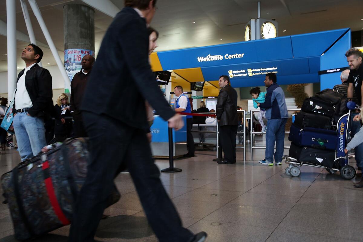 People arrive at the international arrivals terminal at New York's John F. Kennedy Airport.