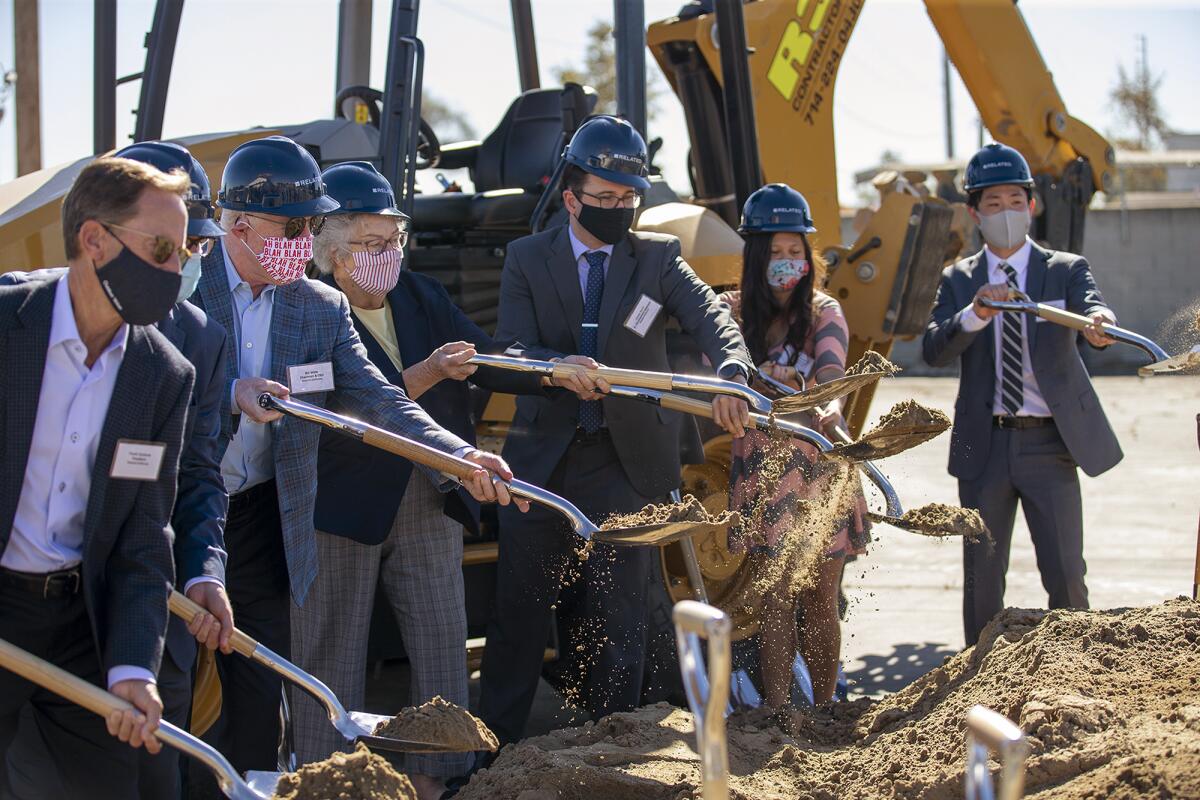 Officials use shovels at a groundbreaking ceremony for Prado.