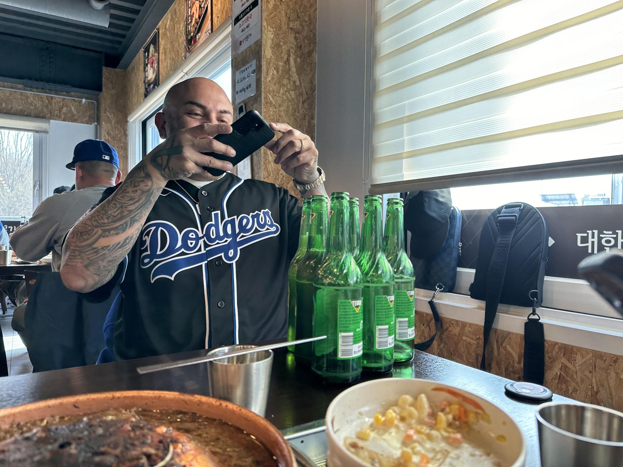 在非军事区吃完午饭后，一名道奇队球迷拍下了他和朋友喝的啤酒的照片。 