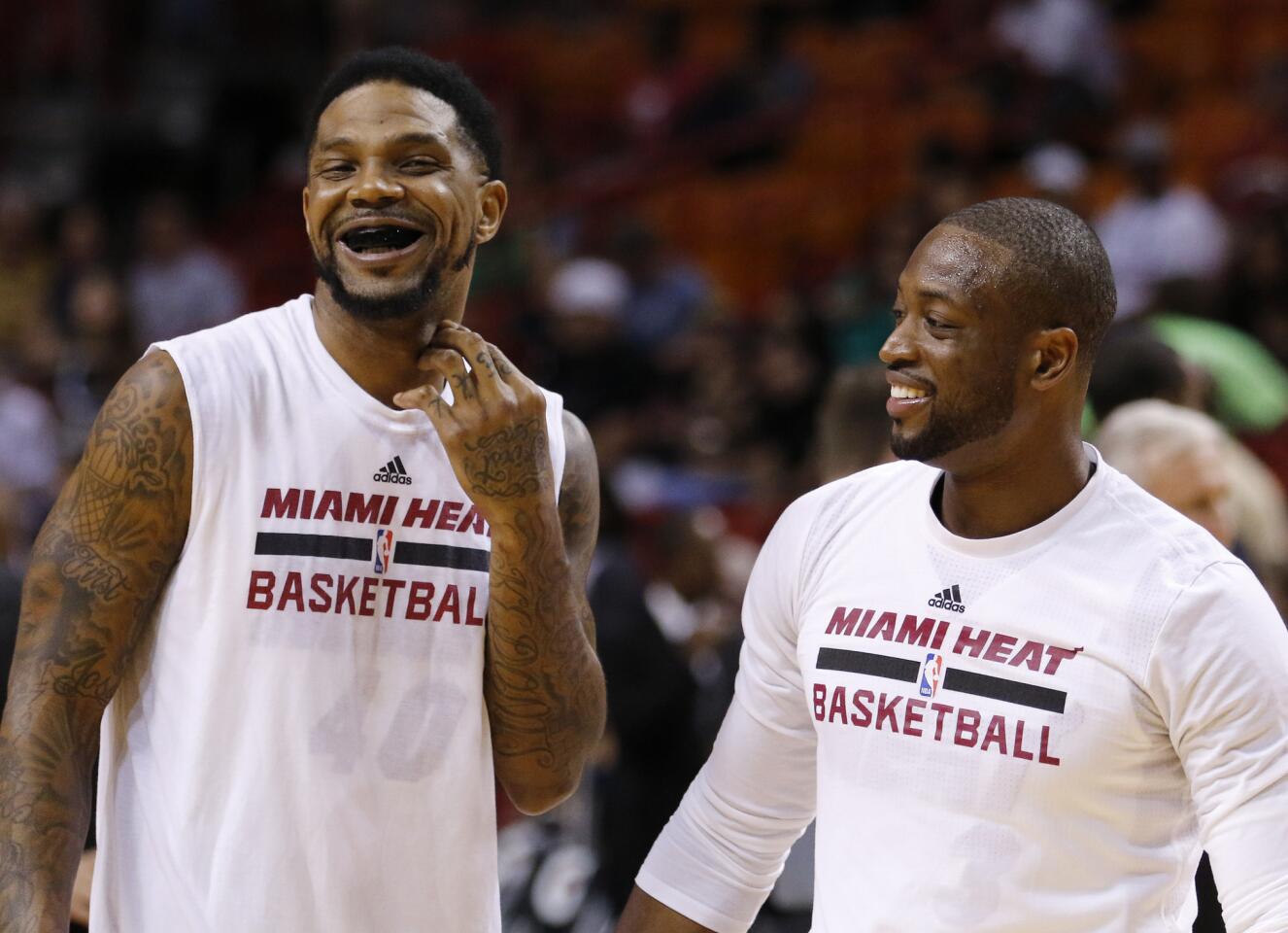 Miami Heat guard Dwyane Wade, right, and forward Udonis Haslem share a laugh during warmups before the Heat met the Brooklyn Nets in an NBA basketball game, Monday, March 28, 2016, in Miami. (AP Photo/Joe Skipper)