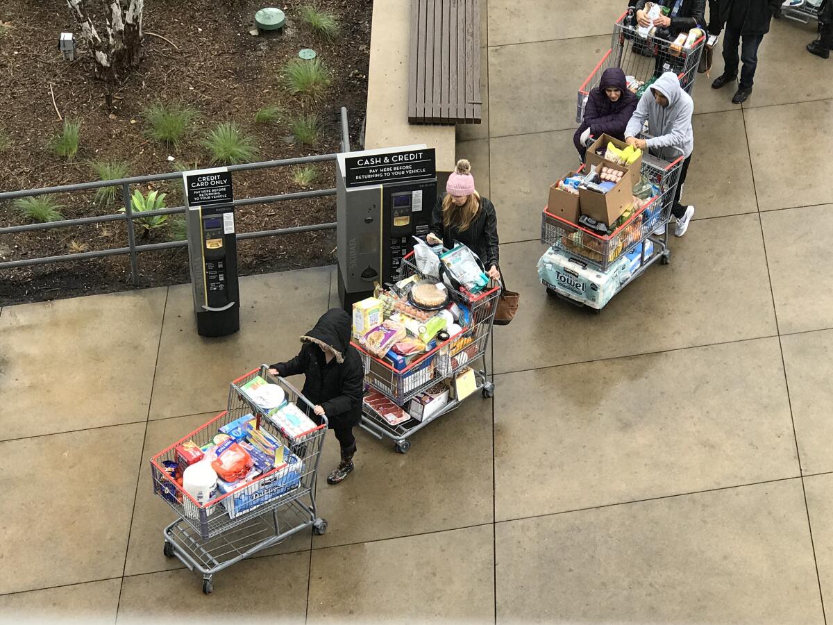 Customers wait in line for the elevator to the parking garage after shopping at the Costco located at the Village at Topanga in Los Angeles.