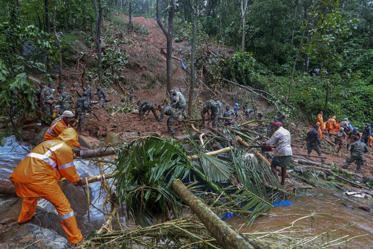 Rescuers search for bodies of victims amist the debris of a landslide following heavy rains atKoottickal in Kottayam district, southern Kerala state, India, Sunday, Oct.17, 2021. More than two dozen people have died in the state due to intense rains which have triggered floods and landslides. (AP Photo)