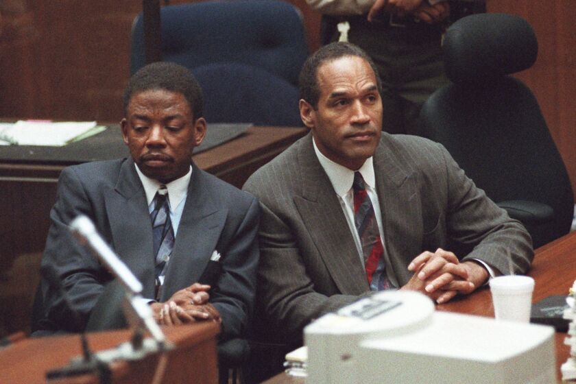 Attorney Carl Douglas, left, sits next to O.J. Simpson while the jury announces that it had reached a verdict on Oct. 2, 1995.