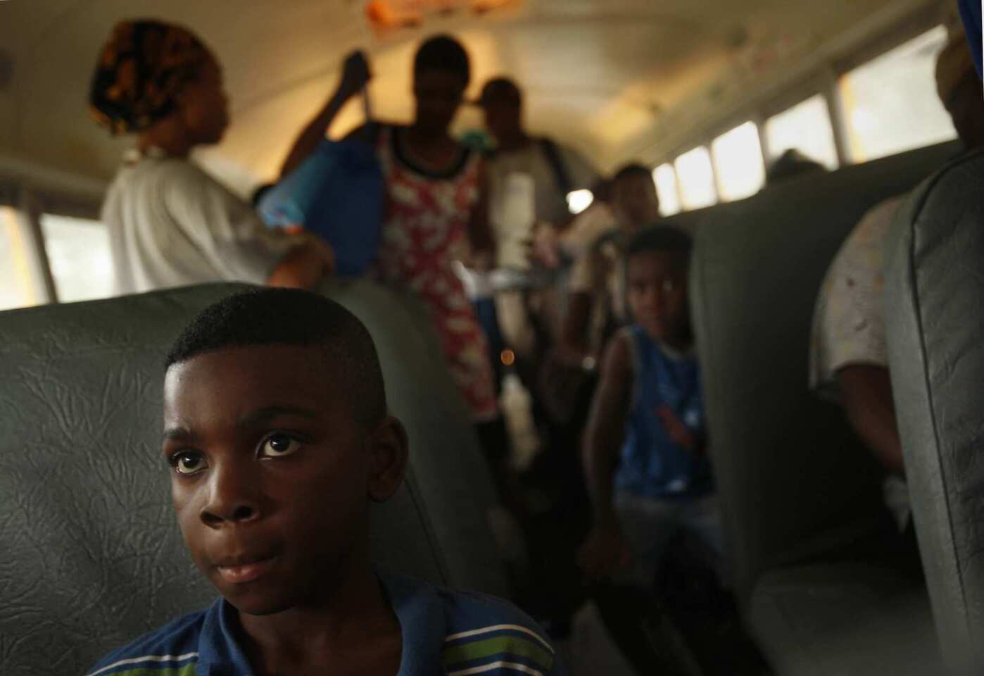 Nine-year-old Reshard Johnson and other residents of Kentwood, La., ride buses to a shelter away from a possible dam break along the Tangipahoa River. (Carolyn Cole/Los Angeles Times)
