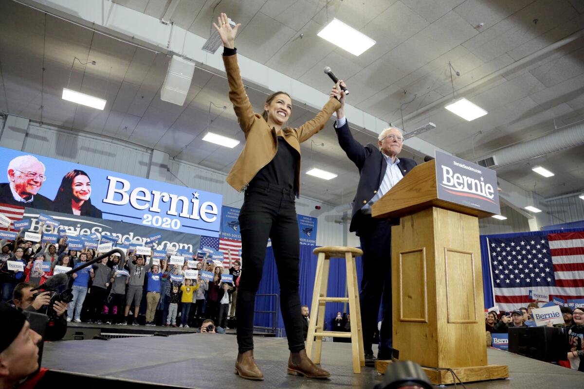Democratic presidential candidate Sen. Bernie Sanders (I-Vt.) and Rep. Alexandria Ocasio-Cortez (D-N.Y.) greet supporters Nov. 8 at Iowa Western Community College in Council Bluffs, Iowa.