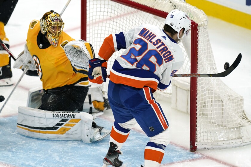 New York Islanders right wing Oliver Wahlstrom (26) hits an airborne puck with his stick as he tries to score against Boston Bruins goaltender Tuukka Rask (40) during the second period of an NHL hockey game Thursday, April 15, 2021, in Boston. (AP Photo/Elise Amendola)