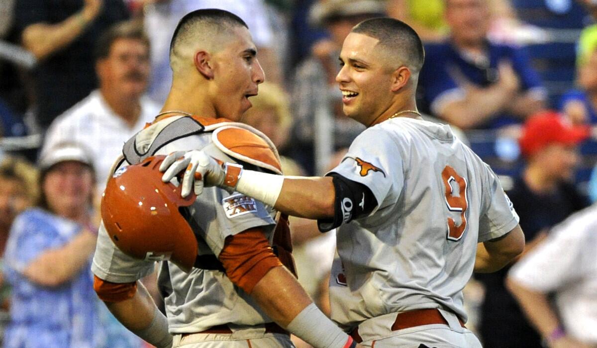 Texas shortstop C.J Hinojosa (9) celebrates with catcher Tres Barrera (1) after hitting a home run against UC Irvine in the seventh inning of their College World Series elimination game Wednesday night.