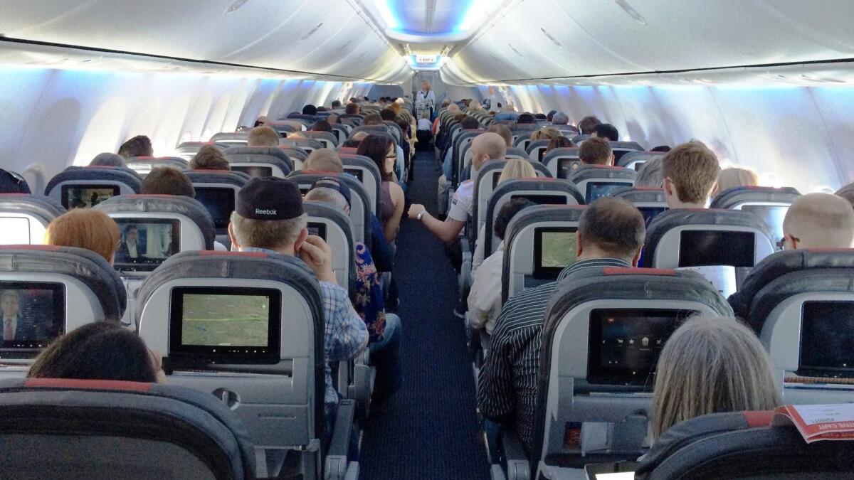 Passengers fly on an American Airlines plane. A study found that basic economy seats are cheaper than standard economy seats, but the saving is even bigger on particular routes.