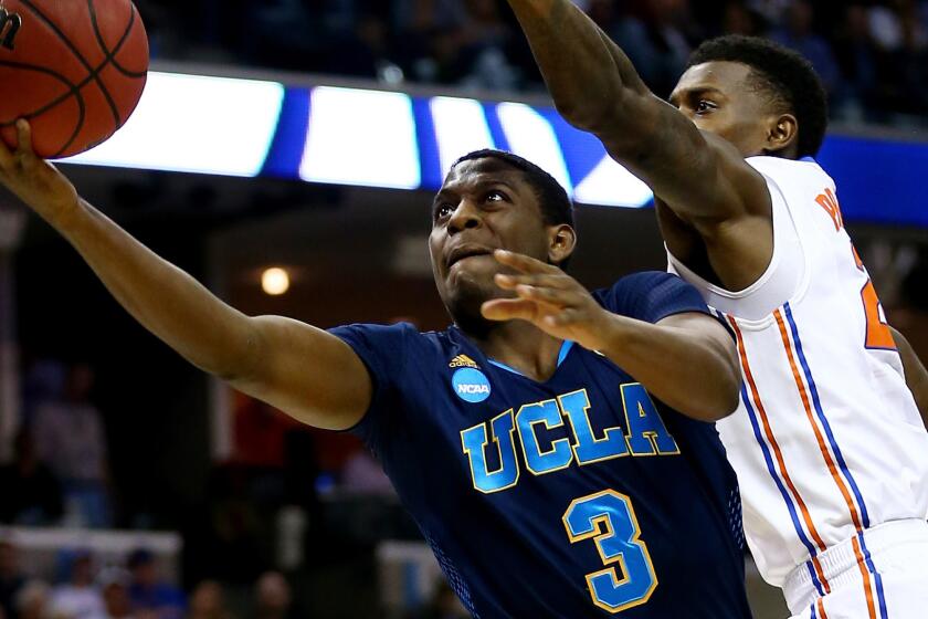 UCLA's Jordan Adams puts up a shot in front of Florida's Casey Prather during the Bruins' loss in the NCAA regional semifinal on March 27, 2014.