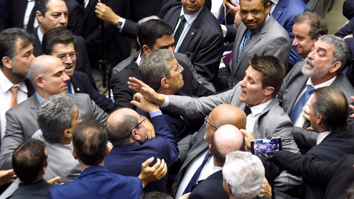 Brazilian lawmakers fight during a session at the Chamber of Deputies in Brasilia on Wednesday as they debated whether President Michel Temer should face trial for alleged corruption.