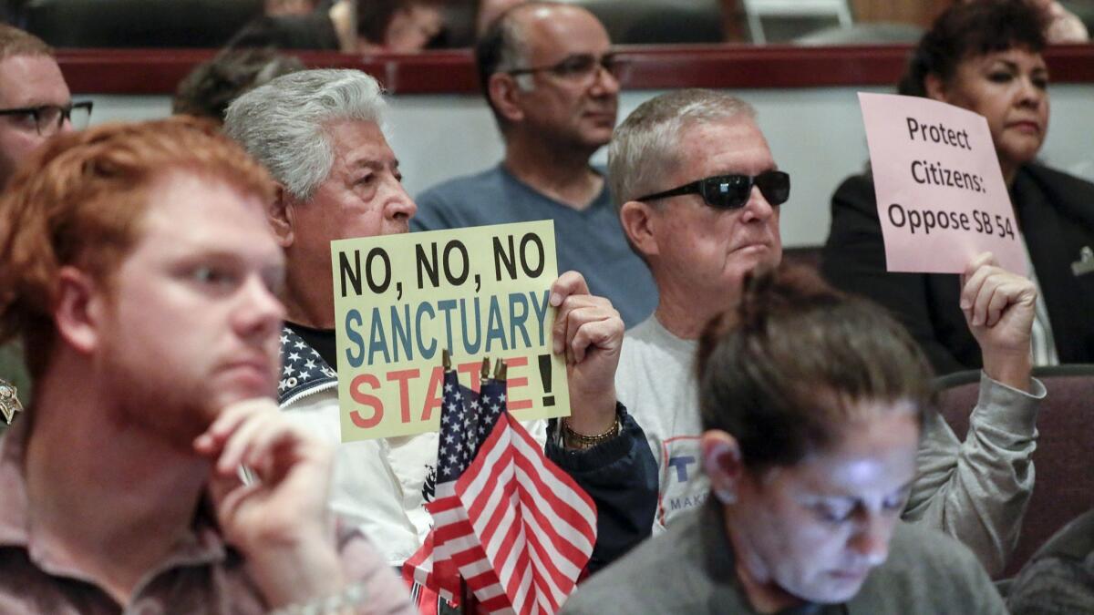 People who oppose California's declaring itself a "sanctuary state" attend Tuesday's Orange County Board of Supervisors meeting in Santa Ana.