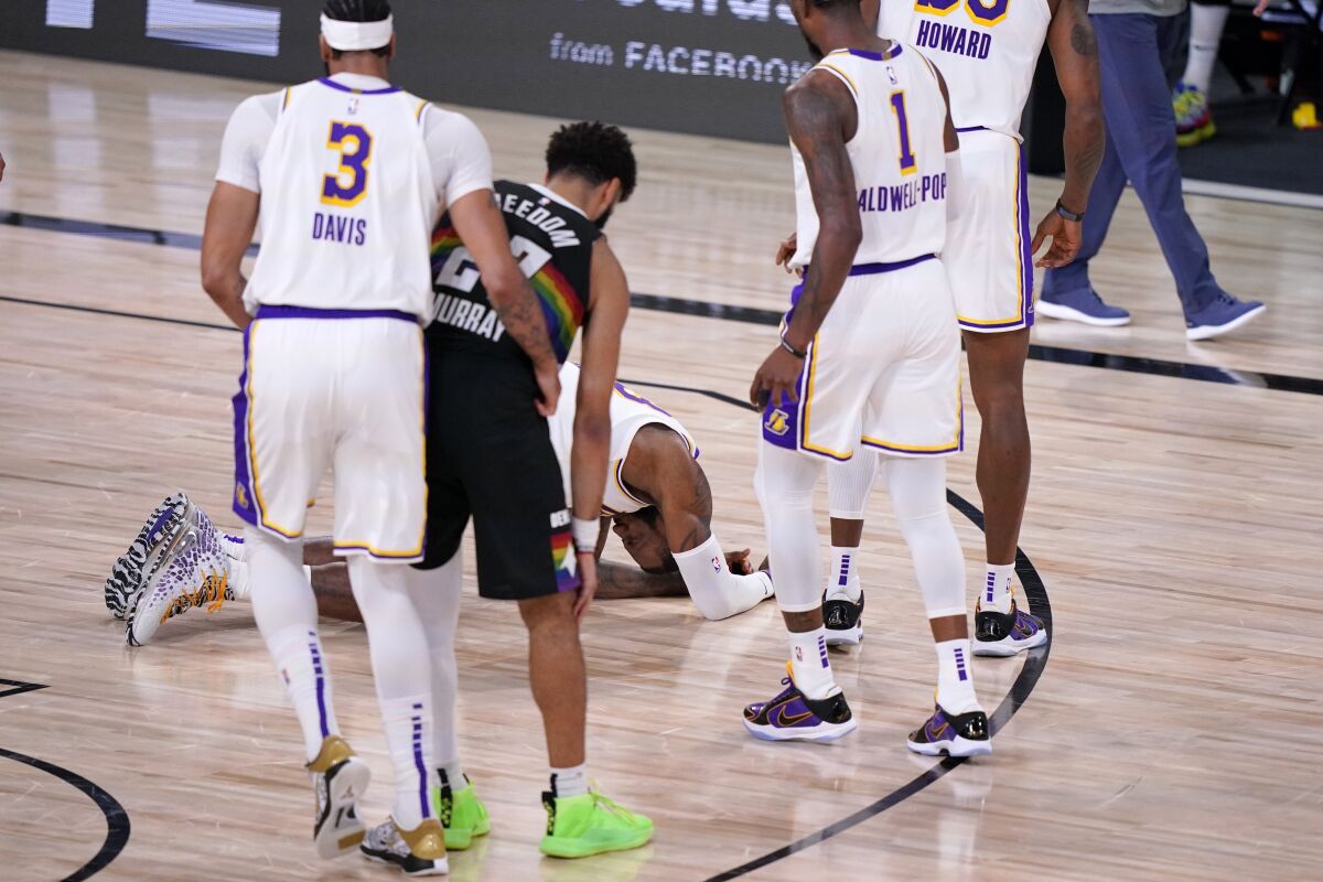 Lakers forward LeBron James gathers himself on the the court after taking an elbow from Nuggets guard Jamal Murray.