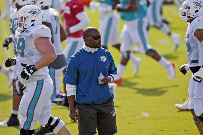 FILE - In this Aug. 21, 2020, file photo, Miami Dolphins head coach Brian Flores watches practice at the NFL football team's training facility in Davie, Fla. The Dolphins roster appears significantly upgraded by the draft and free agency, but the coronavirus pandemic curtailed offseason training. As a result, the Dolphins' 2020 season might be similar to 2019, when they were much better in December than in September. (AP Photo/Lynne Sladky, File)