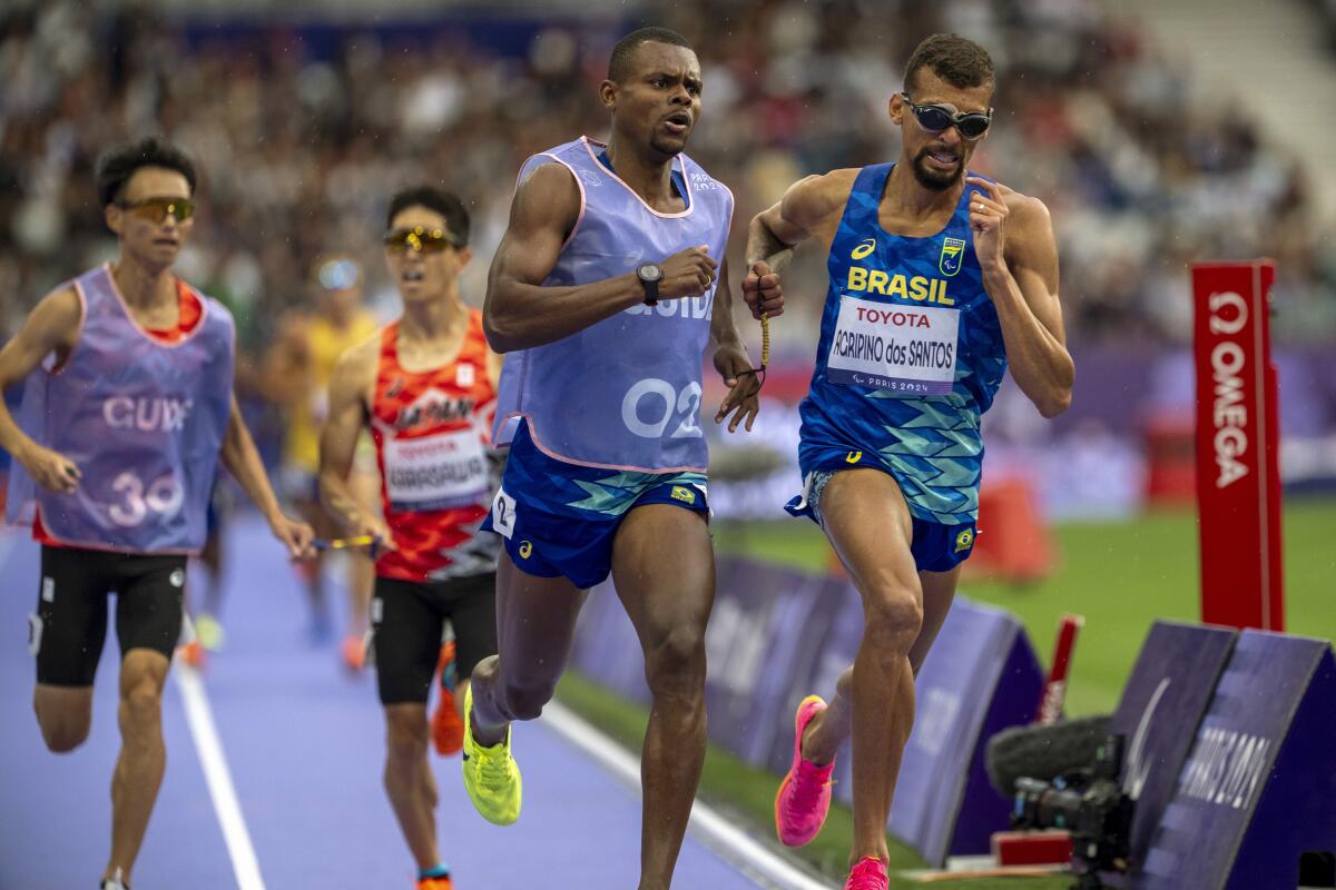 Brazil's Julio Cesar Agripino dos Santo, right, leads during a men's 5,000-meter race at the Paris Paralympics on Friday.