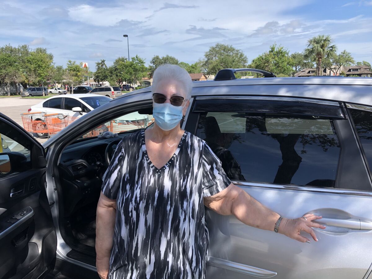 Priscilla Skalka of Pinellas Park, Fla., wearing a surgical mask as she stands by her car.