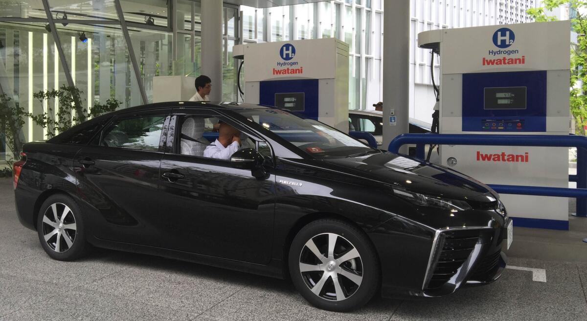 A hydrogen fuel cell car gets a fill-up at a Tokyo hydrogen station.