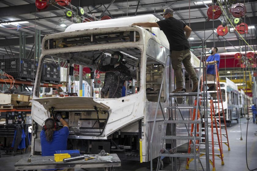 Workers build electric buses at the BYD electric bus factory in Lancaster on July 1, 2021. REUTERS/Mike Blake