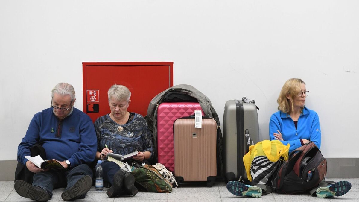 Passengers rest with their luggage at Gatwick Airport on Dec. 21.