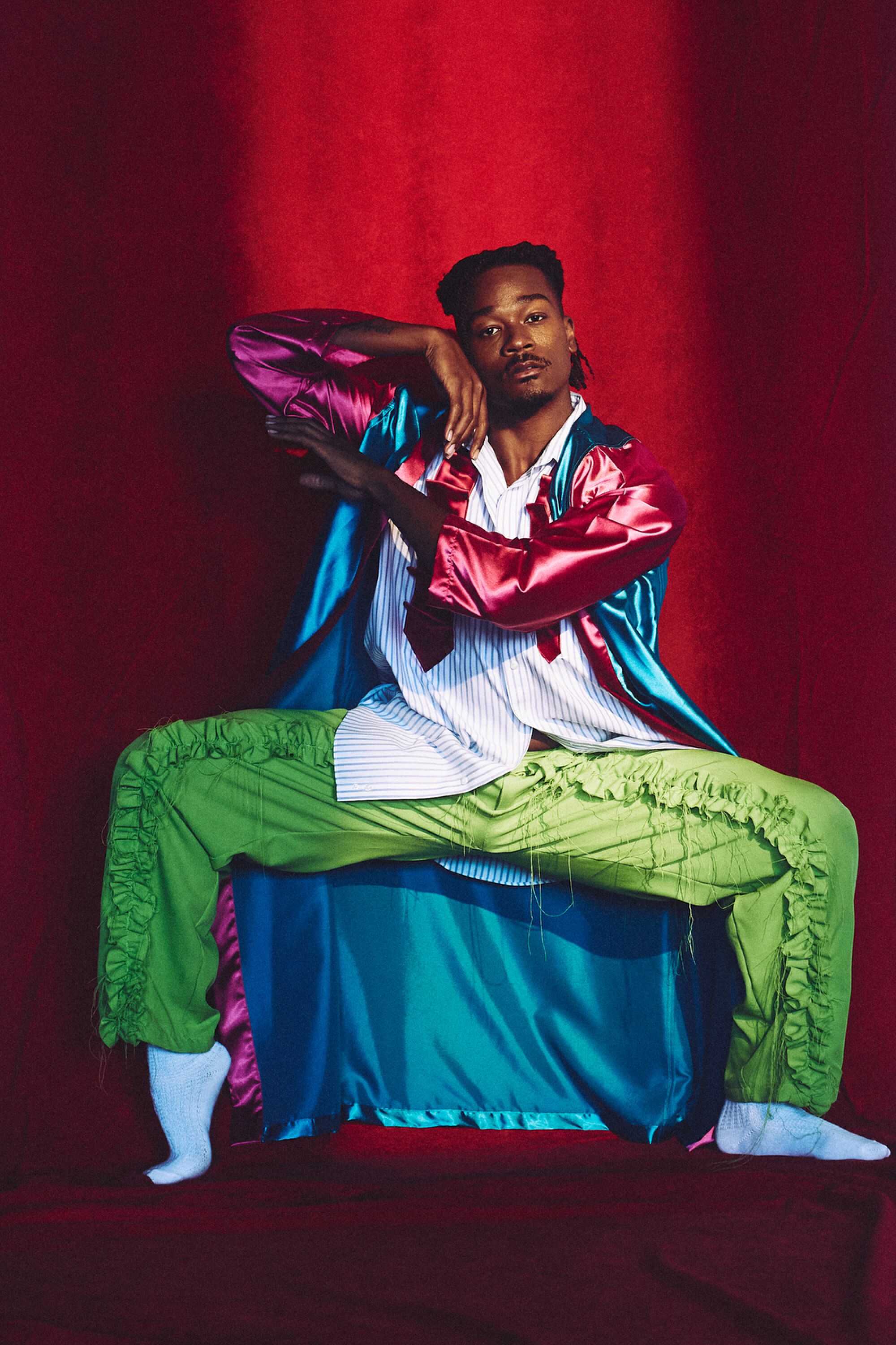 David Adrian Freeland Jr. in a robe and striped button-down shirt by Planeta, and lime green ruffled pants by Río Original.