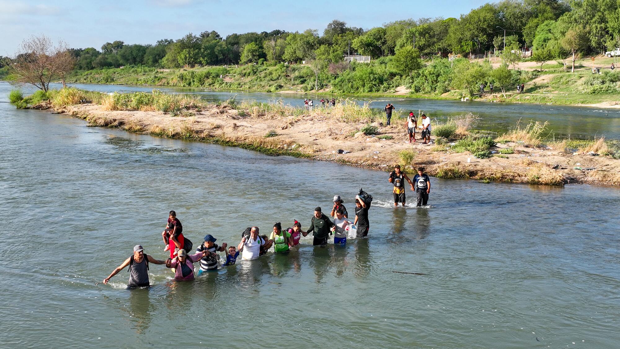 Migrants wade across the Rio Grande from Mexico. 