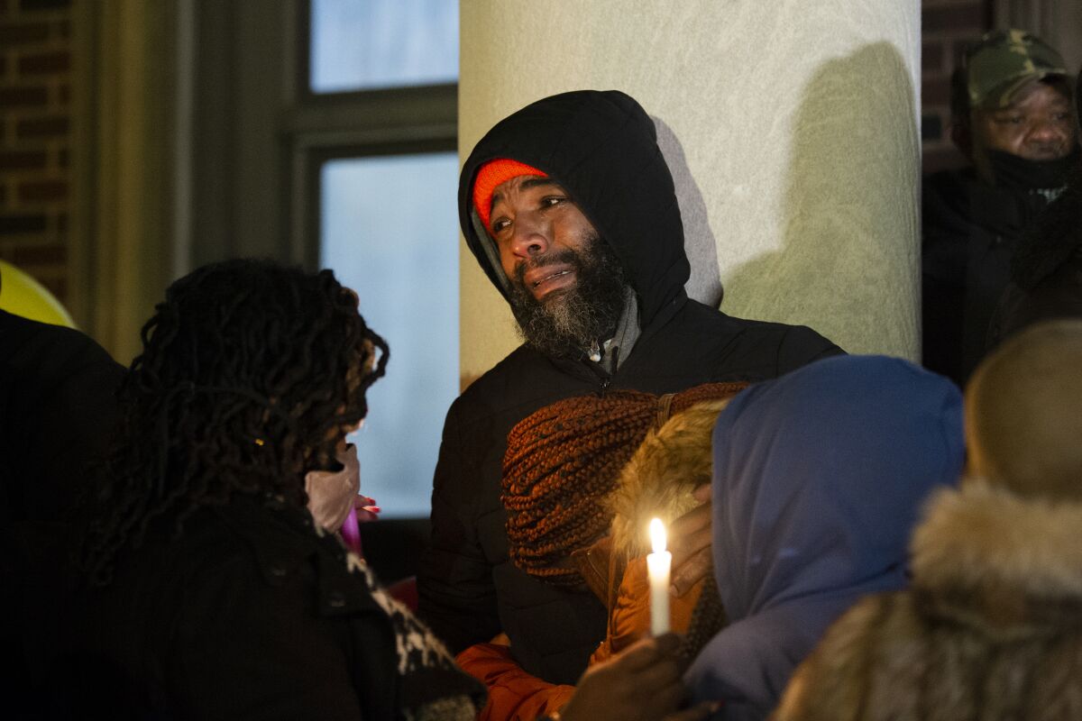 Family members gather by the Bache-Martin School for a vigil to honor the victims of a rowhouse fire, Thursday, Jan. 6, 2022, in Philadelphia. (Joe Lamberti/Camden Courier-Post via AP)
