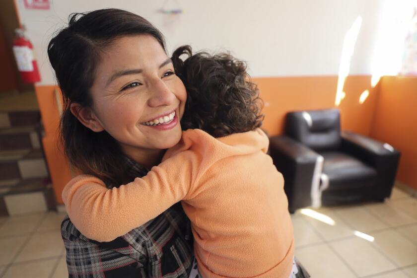 Rocio Martinez Perez, 23, who grew up and still lives at the Hacienda orphanage, hugs a young girl in the orphanage on Wednesday, October 30, 2019 in Tijuana, Mexico.