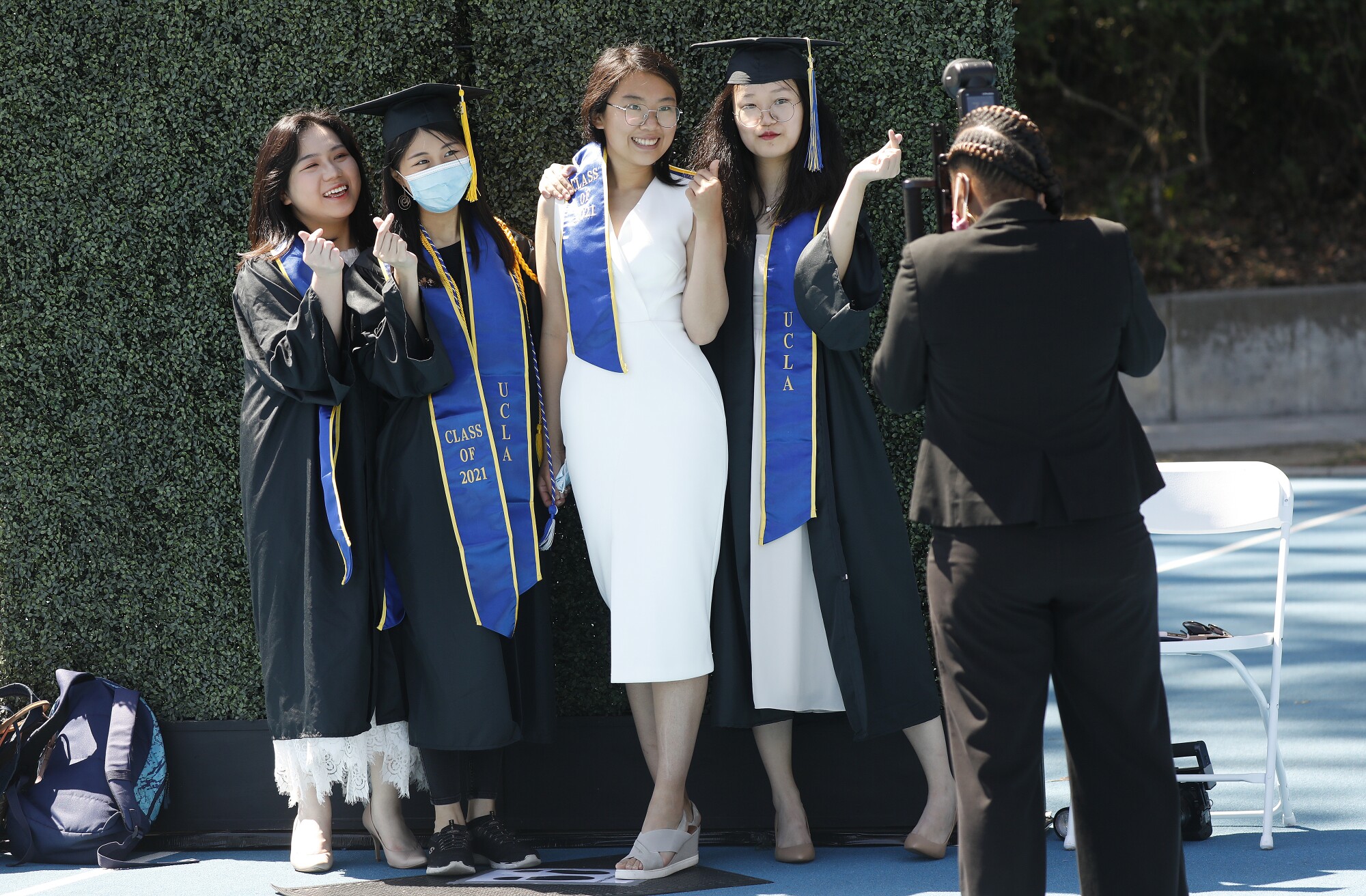 Ziyan Wu, Yuying Wang, Ziqing Jiang and Mingze Li, left to right, hold their fingers together to form a heart