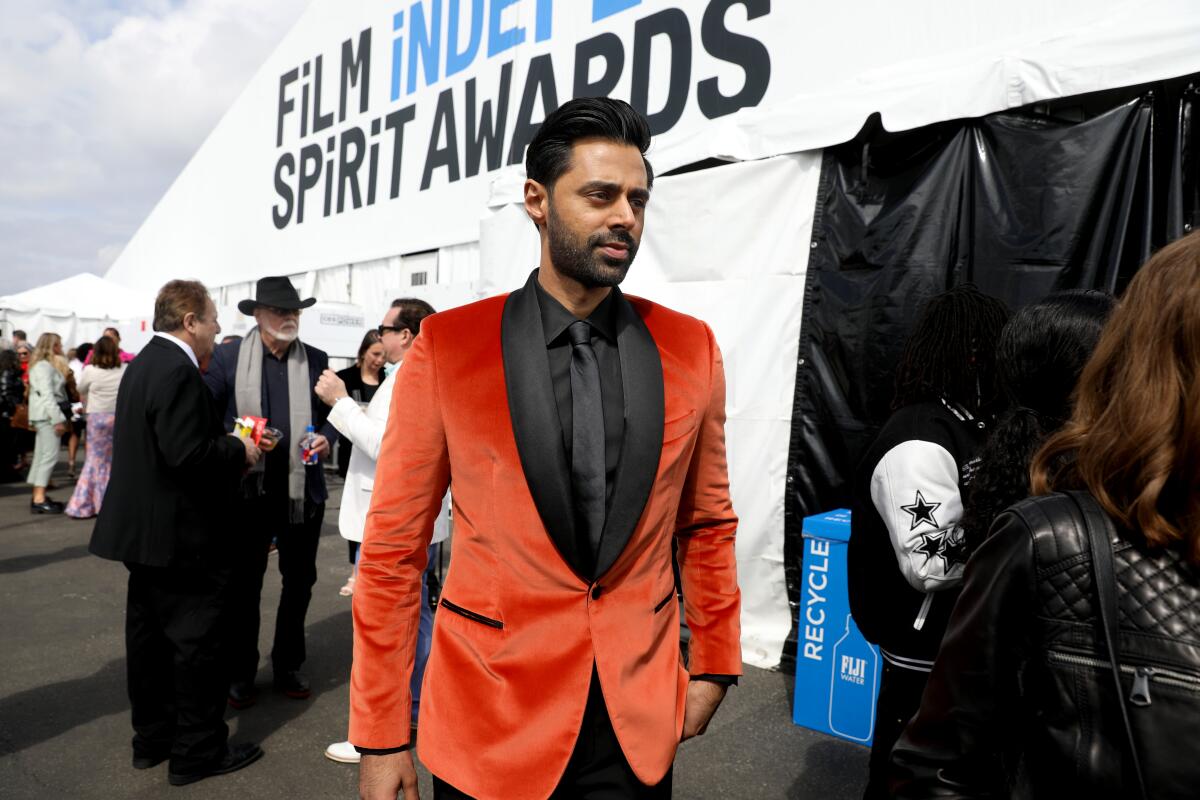 A man in an orange suit outside a tent at an awards show