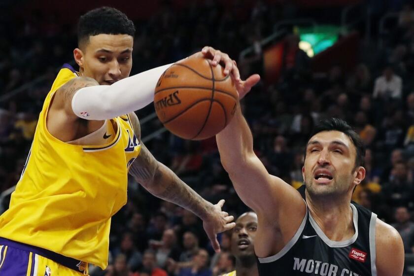 Los Angeles Lakers forward Kyle Kuzma and Detroit Pistons center Zaza Pachulia (27) reach for the rebound during the second half of an NBA basketball game, Friday, March 15, 2019, in Detroit. (AP Photo/Carlos Osorio)