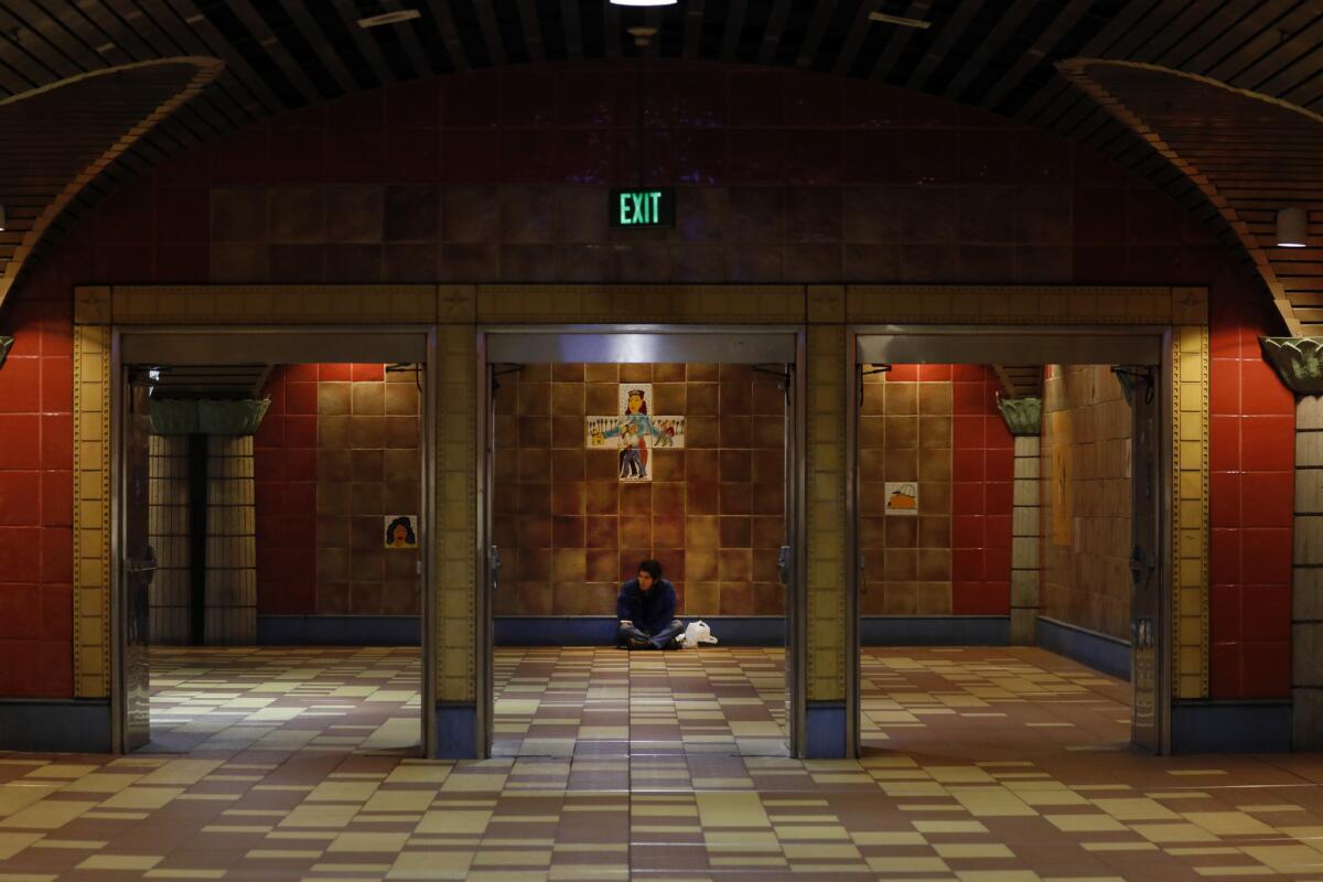 A person sits on the floor at Hollywood/ Vine station in Los Angeles during the 2018 Greater Los Angeles Homeless Count.